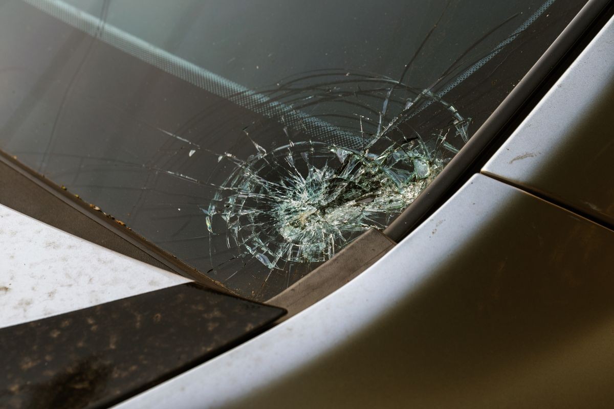 Broken car windshield. Stones on a dirty road from under the wheels at a speed smash car glass. Criminal incidents. Vandals, hooligans mutilated the car, smashed the windshield